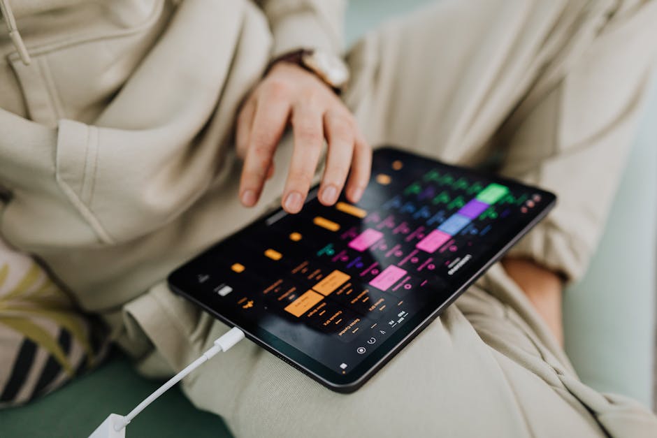 Close-up of a person using a touchscreen tablet with a colorful interface indoors